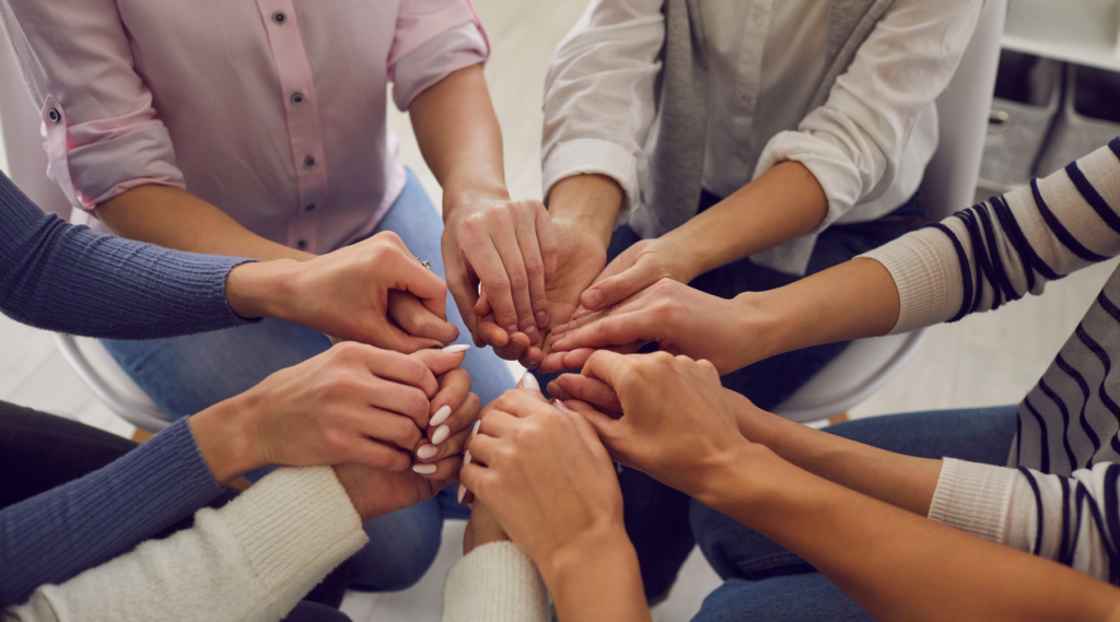 a-group-of-people-holding-hands-in-circle