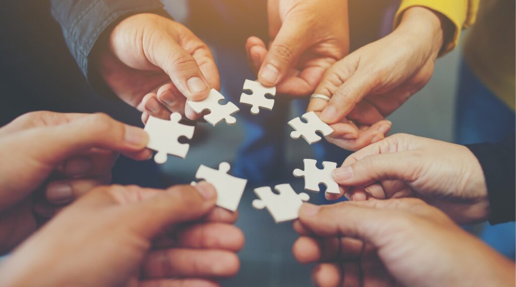 Each hand holding a jigsaw representing harmony in the workplace