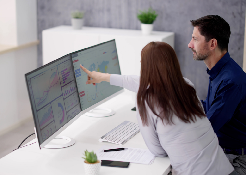 Two coworkers analysing data in front of the PC